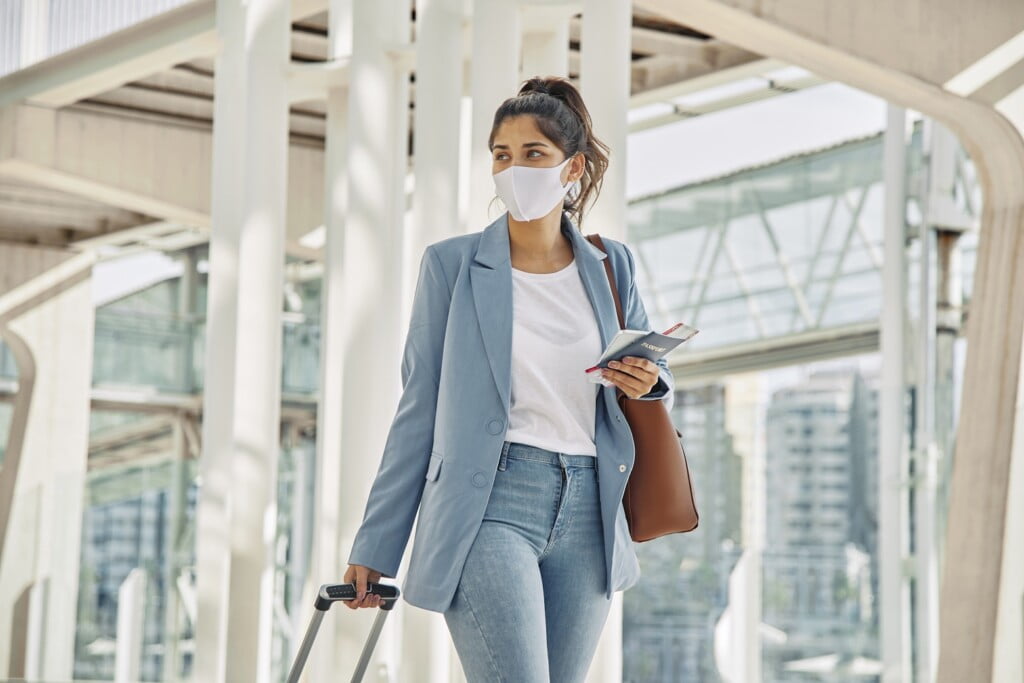 woman-with-luggage-medical-mask-airport-during-pandemic